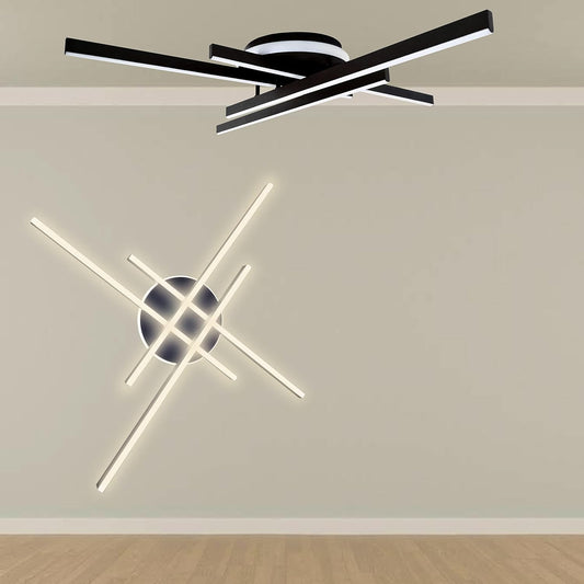 Plafoniera LED moderna con bracci geometrici in nero e bianco su soffitto chiaro con pavimento in legno.